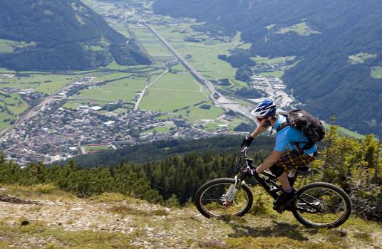 Mountain biker su un sentiero di montagna con vista su Vipiteno e sulla Valle Isarco