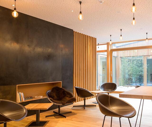 Steindl’s Bar Café; modern seating area with armchairs, a high table and bar stools in front of a large window.
