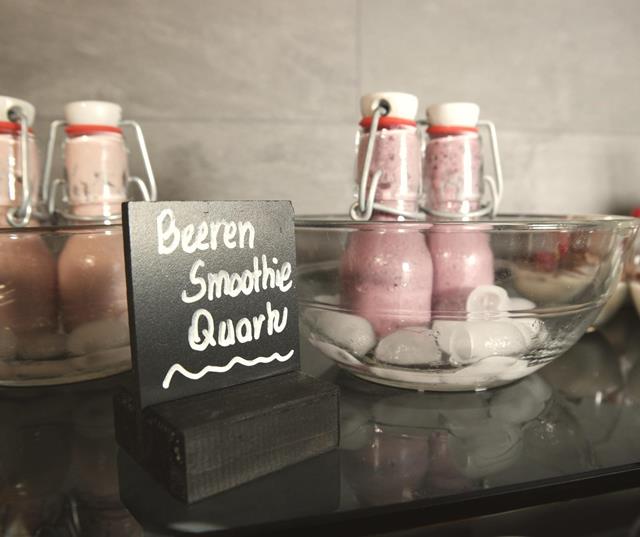 Beeren-Smoothies in kleinen Flaschen auf Eis.