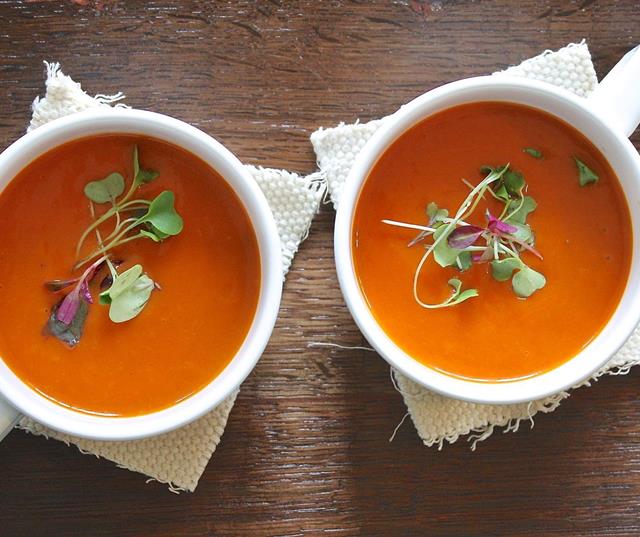 Two tomato soups with cress, served in white cups.
