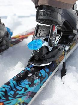 Primo piano di scarponi da sci negli attacchi degli sci sulla neve.