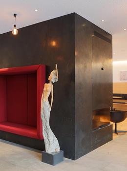 Kunstinstallation mit roter Nische und einer Frauenfigur im modernen Innenbereich des Steindl’s Boutique Hotels.