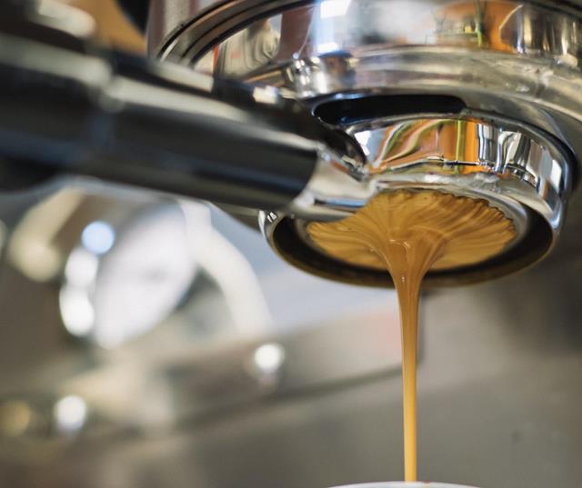 Close-up of a portafilter with coffee flowing out.