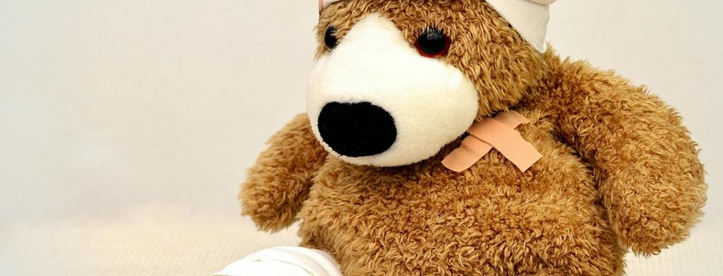 Teddy bear with a bandage on its head and foot.
