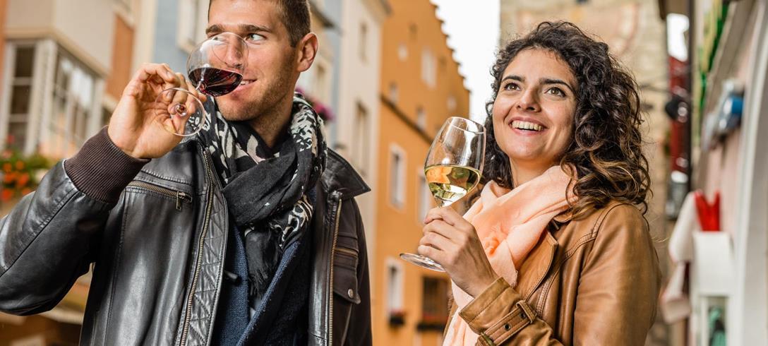 Ein Mann und eine Frau beim Wein trinken in Sterzing.