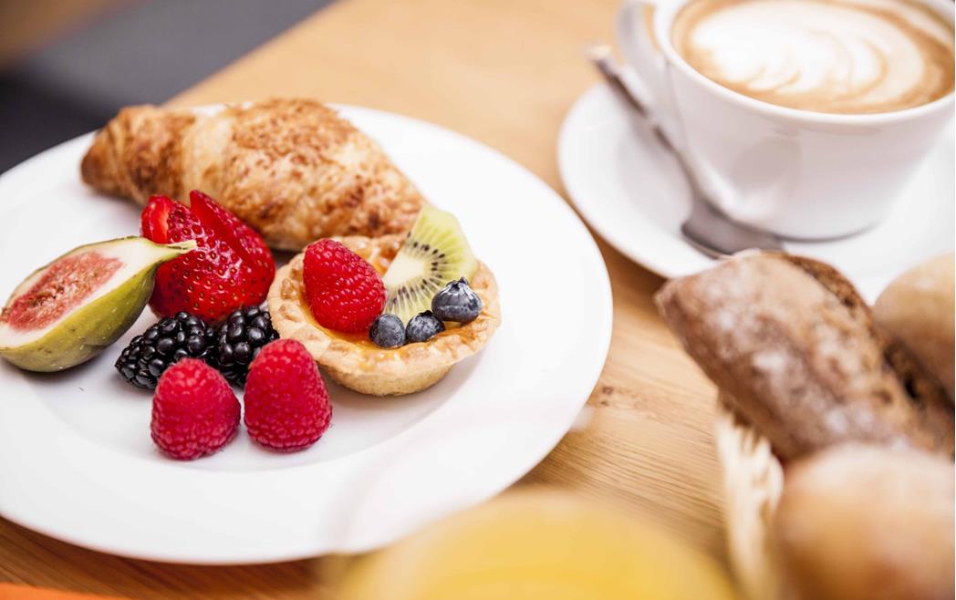 Sweet breakfast with brioche, cake and fresh fruit.