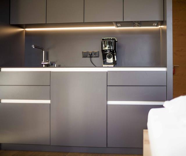 Küchenzeile mit Beleuchtung, Waschbecken und Kaffemaschine